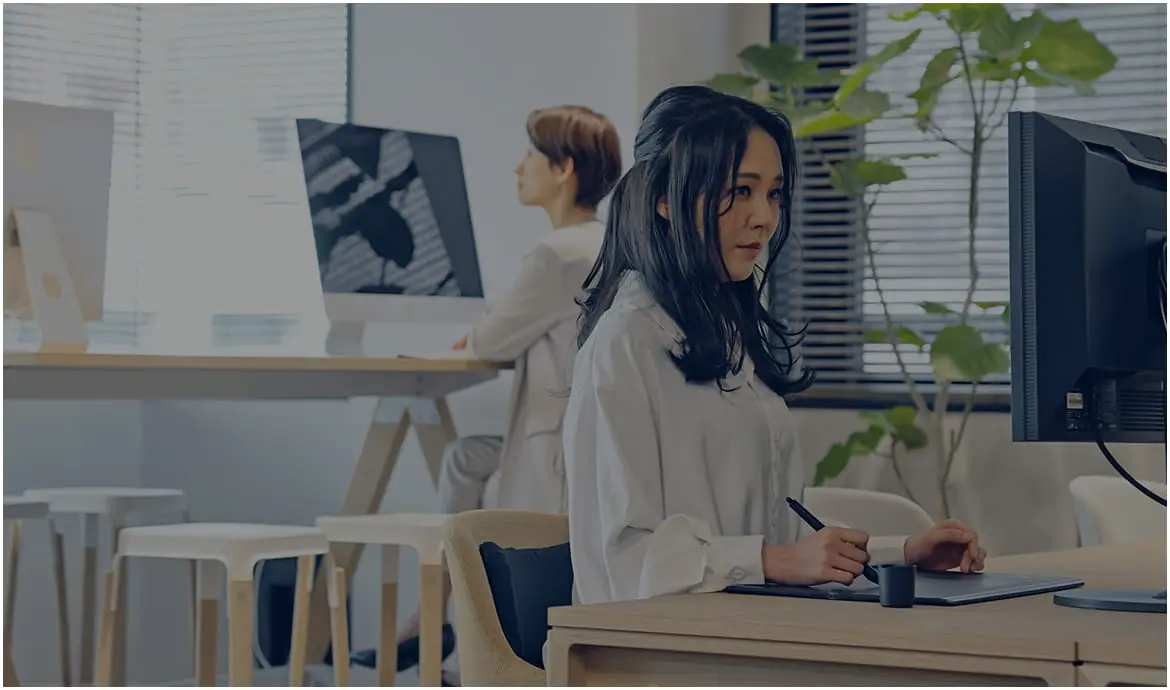 パソコン作業をする女性たちがいる明るいオフィス
