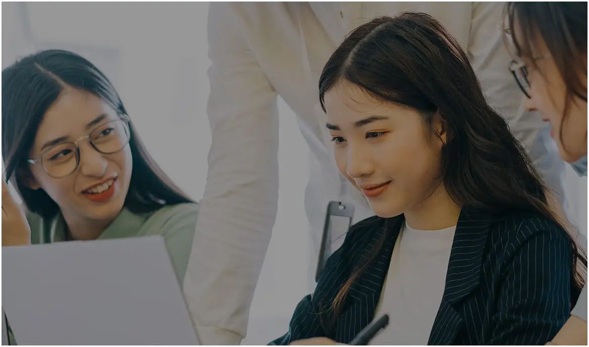 資料を見ながら話し合う3人の女性のビジネスシーン
