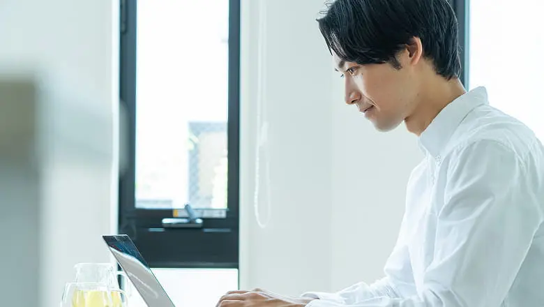 ノートパソコンで作業する男性の横顔