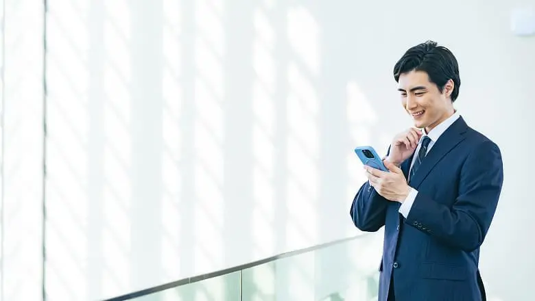 スマートフォンを見るスーツ姿の男性