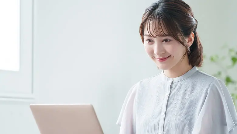 ノートパソコンで作業する女性の様子
